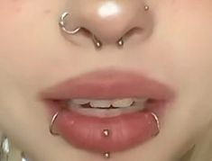 a woman with piercings on her nose and nose ring in front of her face