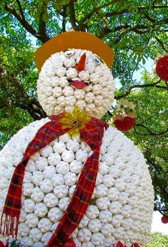 a snowman made out of white balls with a red scarf around it's neck