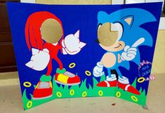 a cardboard cutout of sonic and tails on the ground next to each other in front of a blue background