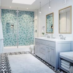 a bathroom with blue and white tiles on the floor, shower stall and sink area