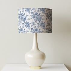 a blue and white lamp sitting on top of a table