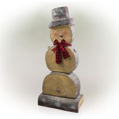 a snowman made out of logs with a red bow