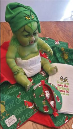 a baby doll with green hair sitting on top of a table next to an oven mitt