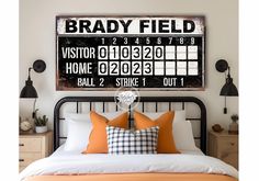 a bed with two pillows and a large sign on the wall above it that says brady field