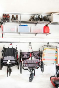 three baby strollers are hanging on the wall next to shoes and other items in baskets