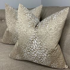 two pillows sitting on top of a couch