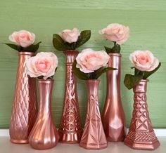 pink flowers are in vases on a shelf