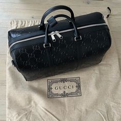 Brand New Authentic Gucci Travel Tote Back, Fully Leather With Embossed Gg Letters. Comes With Dust Bag And Strap. Please No Low Offers, I Will Not Entertain Them. Via Gucci Website :Style 725282 1w3cn 1000 Classic Travel Accessories Are Reimagined In New Dimensions As Part Of The Latest Collection. Gg Leather Combines Softness With The Embossed Allover House Emblem, Playing On Texture And Resulting In A Slightly Shiny Finish. This Duffle Bag Appears In A Black Variation Of The Emblematic Materi Designer Leather Bags With Logo, Elegant Bag With Designer Logo For Everyday Use, Designer Gucci Bag, Elegant Bags With Designer Logo, Designer Bag With Logo For Everyday Luxury, Designer Everyday Luxury Bag With Logo, Gucci Luxury Hobo Bag For Travel, Black Designer Gucci Bag, Gucci Black Everyday Luxury Bags