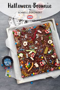 there is a square cake decorated with chocolate and sprinkles on the table