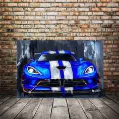 a blue sports car painted on the side of a brick wall in front of a wooden floor