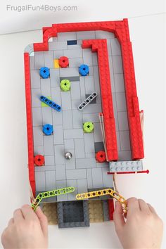 a person is playing with legos and building them in the shape of a maze