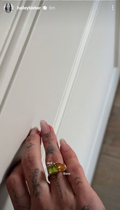 a person with tattoos on their fingers holding onto a door handle and looking at the camera