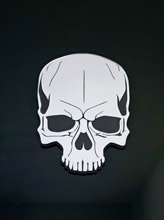 a white skull sticker sitting on top of a black surface