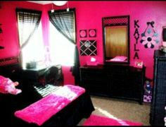 a bedroom decorated in pink and black with lots of accessories on the bed, dressers and mirror