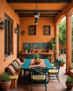 an outdoor dining area with potted plants on the table and colorful tiles on the wall