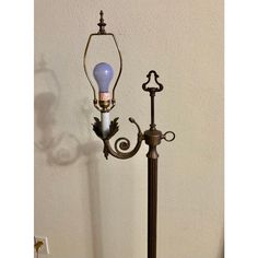 an old fashioned lamp on a table next to a light fixture with a blue glass bulb