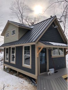 a small house with a metal roof in the snow