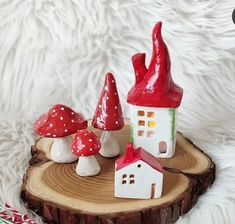 three small red and white gnome houses on a piece of wood