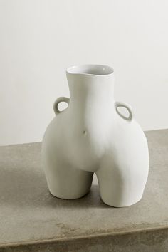 a white vase sitting on top of a table