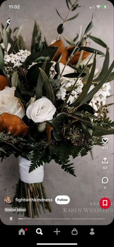 a bouquet of flowers sitting on top of a white table next to a cell phone