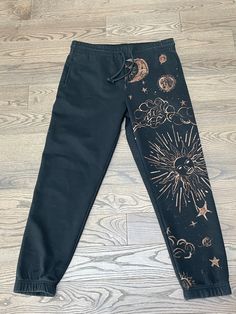 "Unisex pants for sale. Hand painted with bleach.  Size Large. Model by my brother in the second picture who is a size 32\".  And by me in the last picture who is a size 26\". $50 + shipping." Bleach Designs On Sweatpants, Hand Painted Sweatpants, Pants Painted With Bleach, Shirt Painting Design, Bleached Black Pants, Bleach Dye Pants Design, Bleach Dye Sweatpants, Sweatpants Painting Ideas, Bleach Paint Sweatpants