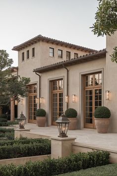 a large house with many windows and plants in the front yard