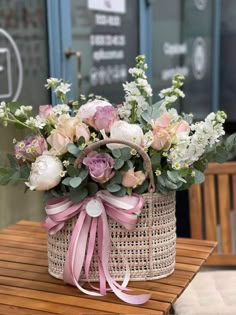 a basket filled with flowers sitting on top of a wooden table