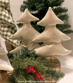 three white christmas trees sitting on top of a table