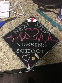 a decorated cap that says nursing school next to other medical supplies on a counter top