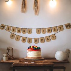 a birthday cake sitting on top of a wooden table next to a sign that says beary first birthday