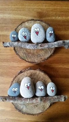 some rocks are sitting on top of a tree branch and one is painted with angry birds