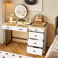 a vanity with two drawers and a mirror on the wall next to a bed in a bedroom