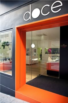 an orange and black store front with the door open