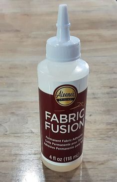 a bottle of fabric fuson sitting on top of a wooden table