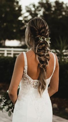 the back of a bride's dress with flowers in her hair