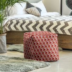 a large bed sitting next to a plant in a bedroom