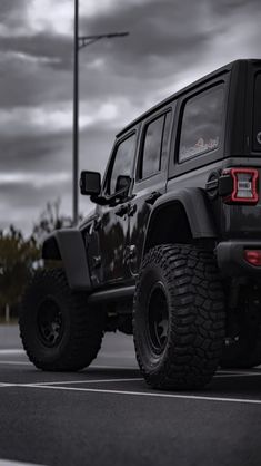 a black jeep is parked in a parking lot