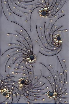 an embroidered fabric with beads and pearls on it