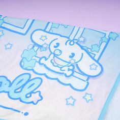 a blue and white blanket with a cartoon dog on it's side, next to a pink wall