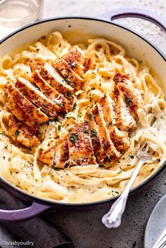 a pan filled with chicken alfredo on top of a table