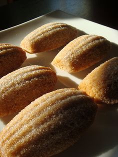 some sugared doughnuts are on a white plate