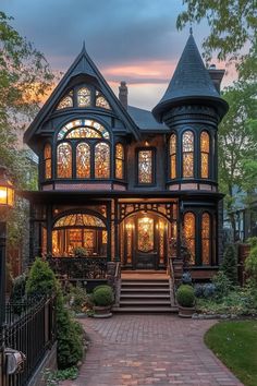 a large victorian style house with stained glass windows on the front and second story is lit up at night