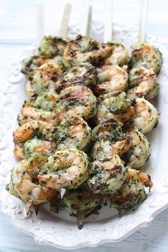 grilled shrimp and broccoli skewers on a white platter with toothpicks