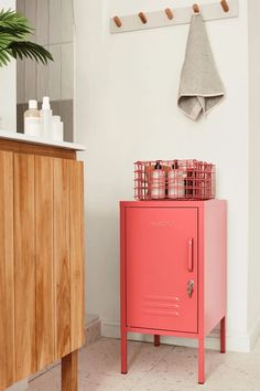 a pink cabinet sitting next to a white wall