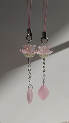 two pink flower shaped glass beads hanging from hooks