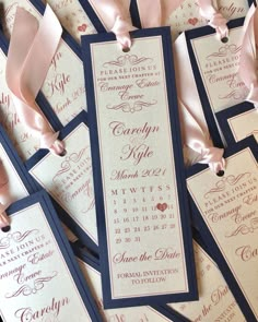 wedding programs are laid out on top of each other and tied with pink satin ribbons