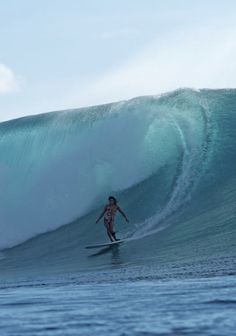 a man riding a wave on top of a surfboard