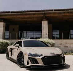 a white audi sports car parked in front of a building with large windows and doors