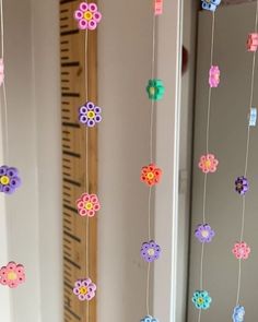 colorful paper flowers hanging from strings in front of a mirror