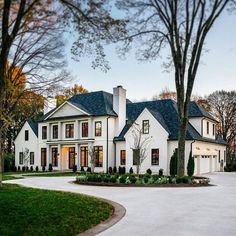 a large white house surrounded by trees and grass